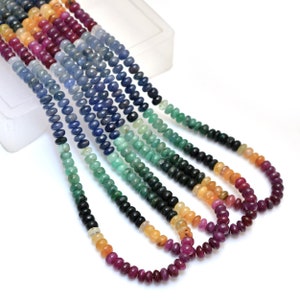 May include: A strand of colorful gemstone beads, including blue, green, red, and yellow beads. The beads are strung on a clear thread and are arranged in a rainbow pattern.