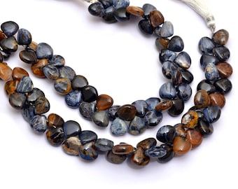 May include: A strand of blue and brown tiger's eye gemstone beads in a heart shape. The beads are strung on a cord with tassels on each end.