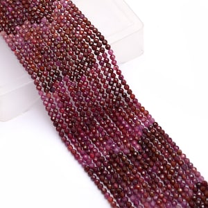 Puede incluir: Una hebra de cuentas de rubí rojo oscuro, cada cuenta está facetada y mide aproximadamente 4 mm de diámetro. Las cuentas están enhebradas en un hilo transparente y están listas para la elaboración de joyas.