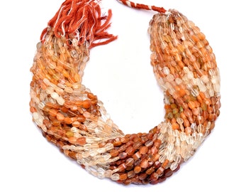 May include: A strand of oval-shaped gemstone beads in shades of orange, brown, and clear. The beads are strung on a thin cord and are ready to be used for jewelry making.