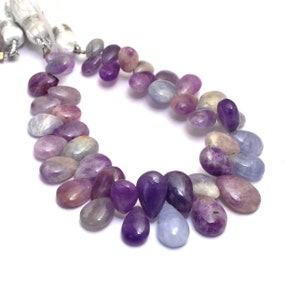 May include: A strand of purple, blue, and white gemstone beads. The beads are teardrop shaped and have a smooth, polished finish.