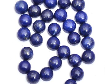 May include: A collection of 25 round, blue lapis lazuli cabochons with gold flecks. The cabochons are approximately 8mm in diameter and are arranged in a loose pile.