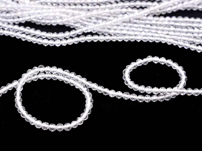 May include: A strand of clear crystal beads, with a smaller strand of the same beads forming a circle.