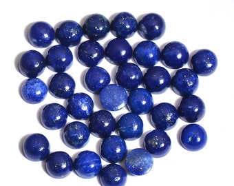 May include: A collection of round, blue lapis lazuli cabochons. The cabochons are smooth and polished, with a deep blue color and flecks of gold.