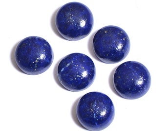 May include: Six round, polished lapis lazuli stones are arranged against a white background. The stones are a deep, rich blue with flecks of gold pyrite, giving them a sparkling appearance. The stones are smooth and spherical.
