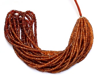 May include: A strand of brown gemstone beads, likely garnet, strung on a red cord. The beads are faceted and have a shiny, translucent appearance. The strand is approximately 46 cm long and is ideal for jewellery making.