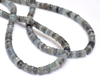 May include: A strand of light blue aquamarine beads, faceted and round, with a slightly darker gray hue. The beads are strung on a clear thread and are approximately 4mm in diameter.
