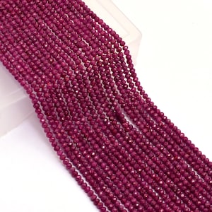 Può includere: Fili di piccole perline sfaccettate di colore rosso intenso. Le perline sono infilate insieme, creando un aspetto fluido e strutturato. Le perline sono di un ricco colore rosso scuro e le sfaccettature catturano la luce, creando un effetto scintillante. Per la creazione di gioielli.