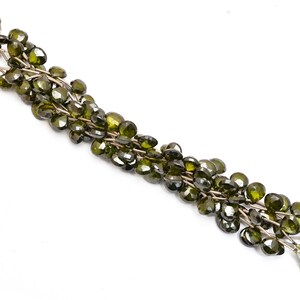 May include: A strand of dark green faceted gemstone beads, strung on silver wire. The beads are heart-shaped and have a glossy finish.