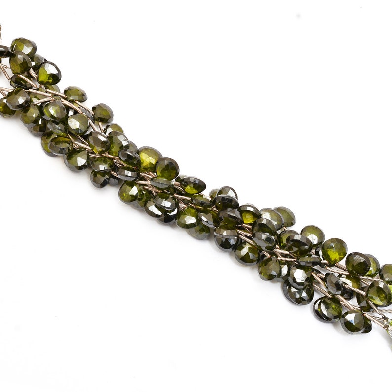 May include: A strand of dark green faceted gemstone beads, strung on silver wire. The beads are heart-shaped and have a glossy finish.