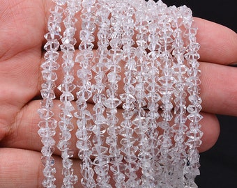 May include: A strand of clear quartz crystal beads, each bead is faceted and has a diamond shape. The beads are strung on a clear thread and are approximately 4mm in size.