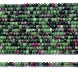 May include: A strand of green, black, and pink faceted gemstone beads. The beads are approximately 4mm in diameter and are strung on a clear elastic cord.