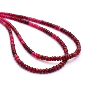 May include: Two strands of faceted ruby beads in varying shades of red and pink. The beads are small and evenly sized, creating a delicate and elegant necklace.