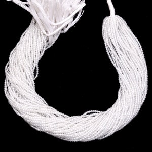 May include: A strand of white glass beads, perfect for jewelry making or crafting projects.