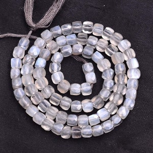Peut inclure: Un brin de perles de pierre de lune blanche, chaque perle est facetée et de forme carrée.