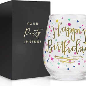 May include: A clear glass wine glass with a gold "Happy Birthday" inscription and colorful confetti pattern. The glass is packaged in a black box with the words "Your Party Inside!" printed on it.