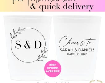 May include: Two white plastic cups with black text and designs. The first cup has a circle with a floral design and the initials "S & D". The second cup says "Cheers to Sarah & Daniel! March 21, 2022". The cups are available in 9oz, 10oz, 12oz, 16oz, and 20oz sizes.