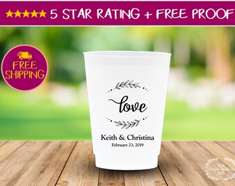 May include: White plastic cup with a black and white design that says "love" with a floral wreath around it. The cup also has the text "Keith & Christina" and "February 23, 2019" printed on it.