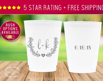 May include: Two white plastic cups with gray text. One cup has the text "l+k" with a small heart and a wreath of leaves. The other cup has the text "6.16.18".