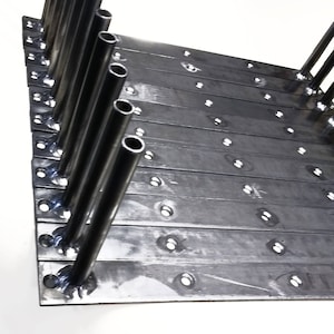 May include: A stack of dual rod brackets, each with a 40.6 cm variety. The brackets are made of dark metal with a series of holes and angled rods. The text "DUAL ROD BRACKET 16" VARIETY" is displayed in bold, black letters.