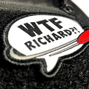 Pode incluir: Um remendo bordado branco e preto com um bal&atilde;o de fala que diz "WTF Richard?!" em texto preto. O bal&atilde;o de fala tem uma agulha vermelha e preta saindo dele.