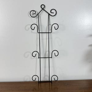 Suporte de parede vintage em arame de metal preto para 3 pratos com decoração em pergaminho.