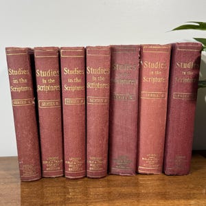 Könnte beinhalten: Ein Set aus sieben kastanienbraunen Hardcover-Büchern mit dem Titel Studies in the Scriptures, angeordnet in numerischer Reihenfolge von Serie 1 bis Serie 7. Jeder Buchrücken zeigt goldene Schriftzüge und den Verlagsnamen unten.