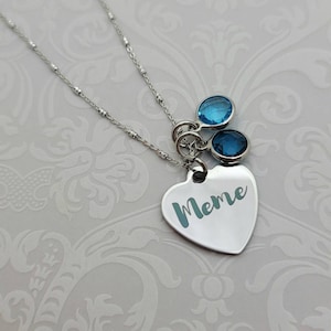 May include: A silver necklace with a heart pendant that says "Meme" and two blue crystal charms.