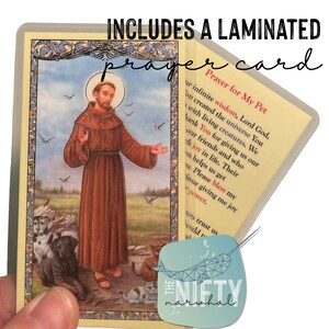 May include: A laminated prayer card featuring Saint Francis of Assisi with animals. The card includes a prayer for pets, "Prayer for My Pet: Our infinite wisdom, Lord God, You created the universe You with living creatures. We thank You for giving us our friends and who bring joy in life. Their presence helps us get through. Please bless my continue giving me joy and power."
