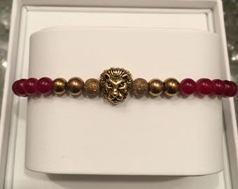 Burgandy and gold bracelet with gold lion head accent.