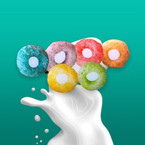 May include: A splash of milk with colourful cereal rings in shades of pink, yellow, green, and blue.
