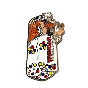 May include: A white and orange enamel pin featuring a cartoon character holding a bag of bread. The bag is decorated with colourful dots and the text "WUNDAR ENRICHED BREAD".