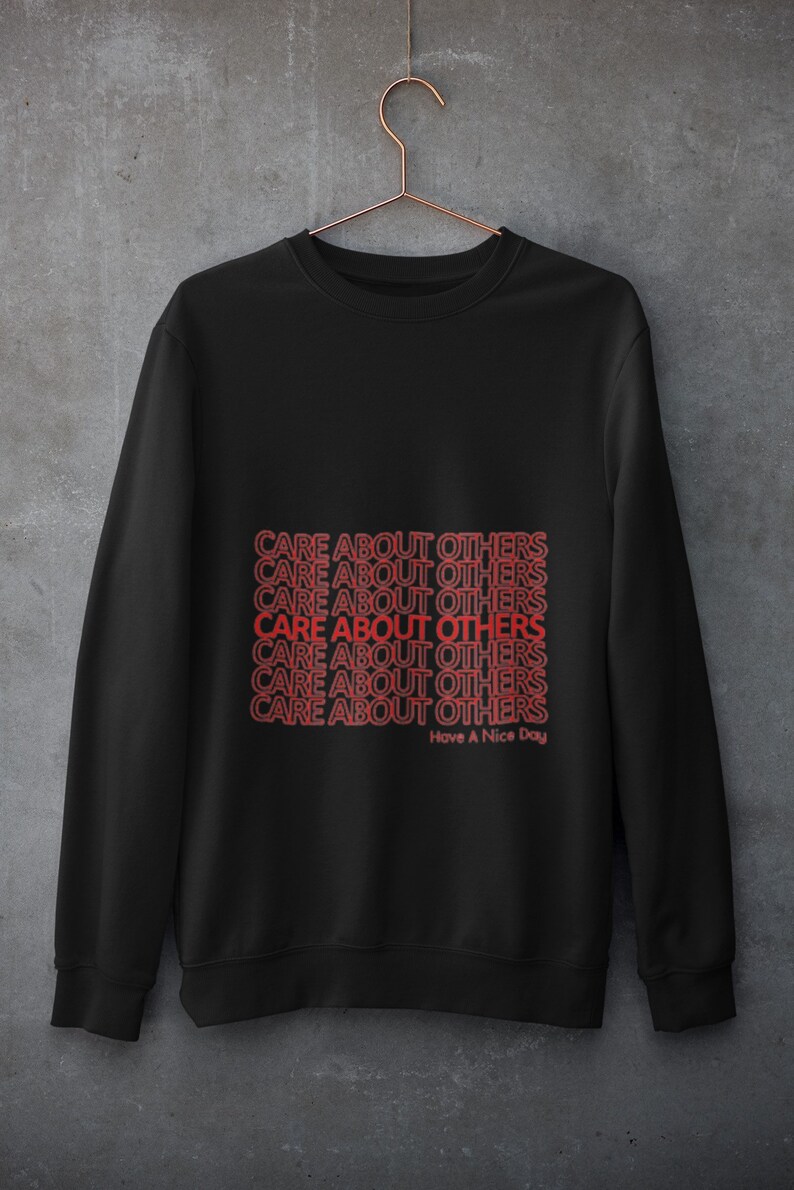 May include: Black sweatshirt with the phrase "CARE ABOUT OTHERS" repeated multiple times in red text. The text is stacked vertically and the phrase "Have A Nice Day" appears below the repeated phrase.
