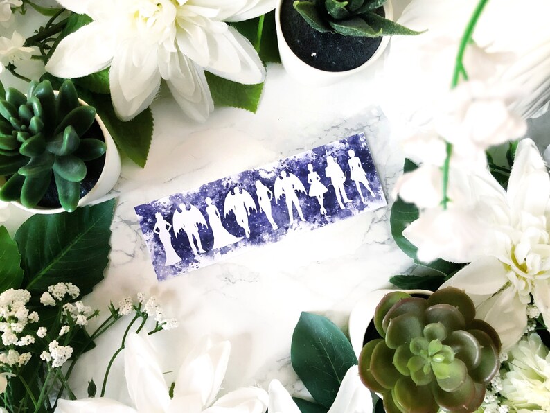 May include: A white card with a purple watercolour background and white silhouettes of people. The card is surrounded by white flowers and green succulents.