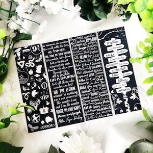 May include: Four black and white bookmarks with quotes and illustrations from the book series A Court of Thorns and Roses. The bookmarks feature quotes such as "No Mourners, No Funerals" and "We the Legion".