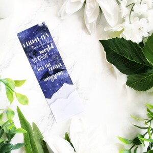 May include: A blue and white bookmark with a quote about the world and a bat with a large wingspan. The quote reads "I figure it's time for the world to know who really has the largest wingspan."