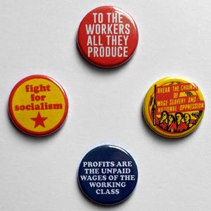Peut inclure: Quatre badges ronds avec des slogans politiques. Un bouton rouge dit "TO THE WORKERS ALL THEY PRODUCE". Un bouton jaune dit "fight for socialism" avec une &eacute;toile rouge. Un autre bouton jaune dit "BREAK THE CHAINS OF WAGE SLAVERY AND NATIONAL OPPRESSION". Le dernier bouton est bleu et dit "PROFITS ARE THE UNPAID WAGES OF THE WORKING CLASS."