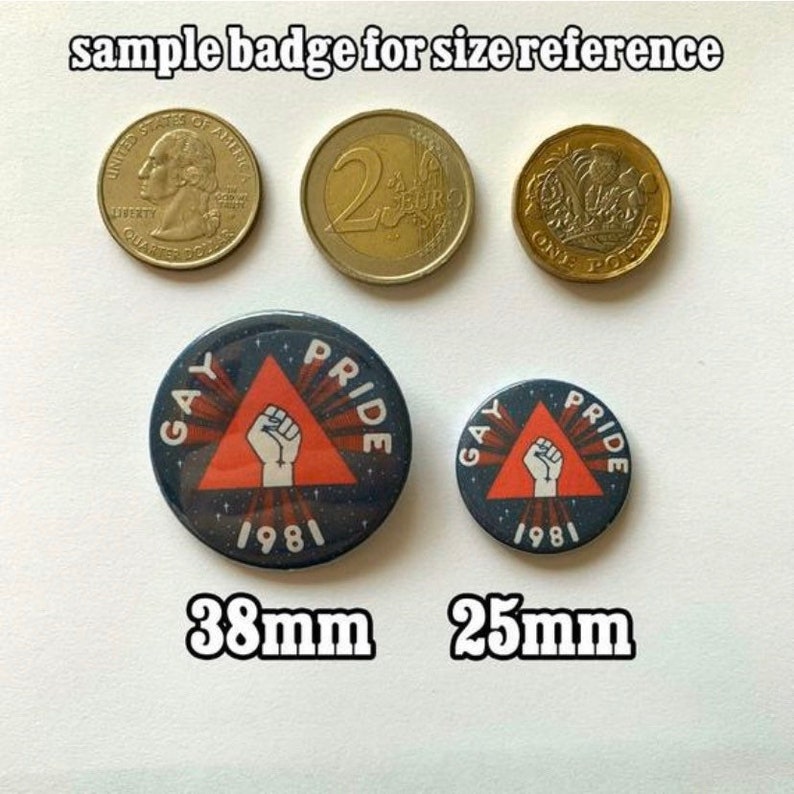 Puede incluir: Dos botones redondos con pin, con fondo negro y un tri&aacute;ngulo rojo con un pu&ntilde;o blanco en el centro. El texto "Gay Pride 1981" est&aacute; impreso en blanco alrededor del tri&aacute;ngulo. El bot&oacute;n m&aacute;s grande tiene 38 mm de di&aacute;metro y el m&aacute;s peque&ntilde;o 25 mm de di&aacute;metro.