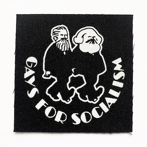 May include: Black and white iron-on patch with a cartoon image of two men with beards, one on top of the other. The text around the image reads "Gays for Socialism".