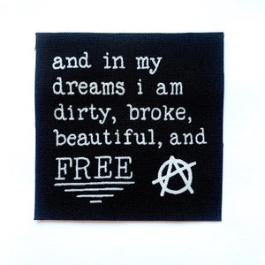 May include: A black square patch with white embroidered text: "and in my dreams i am dirty, broke, beautiful, and FREE". Anarchy symbol is on the right.