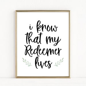 Könnte beinhalten: Ein goldfarbener gerahmter Druck mit dem Text "i know that my Redeemer lives" in schwarzer Kursivschrift. Der Text ist von zwei kleinen grünen Zweigen umgeben.
