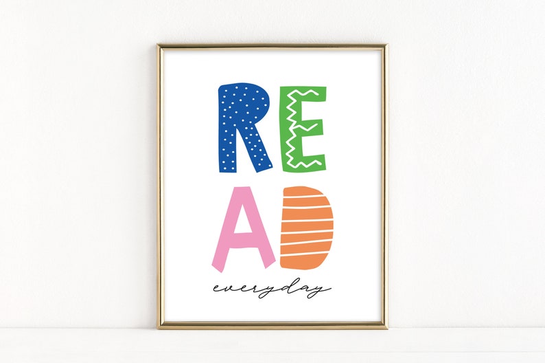May include: A gold framed print with the word "READ" in colorful, stylized letters and the text "everyday" below. The letters are blue, green, pink, and orange.