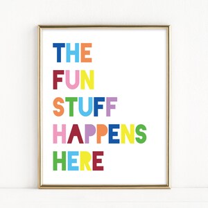Może przedstawiać: Wydruk w ramie z tekstem "THE FUN STUFF HAPPENS HERE" w kolorowych literach. Litery są w r&oacute;żnych kolorach, w tym niebieskim, czerwonym, ż&oacute;łtym, zielonym, r&oacute;żowym i pomarańczowym.