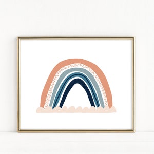May include: A framed print of a rainbow with a peach, blue, and navy color scheme. The rainbow is depicted with a white cloud base.