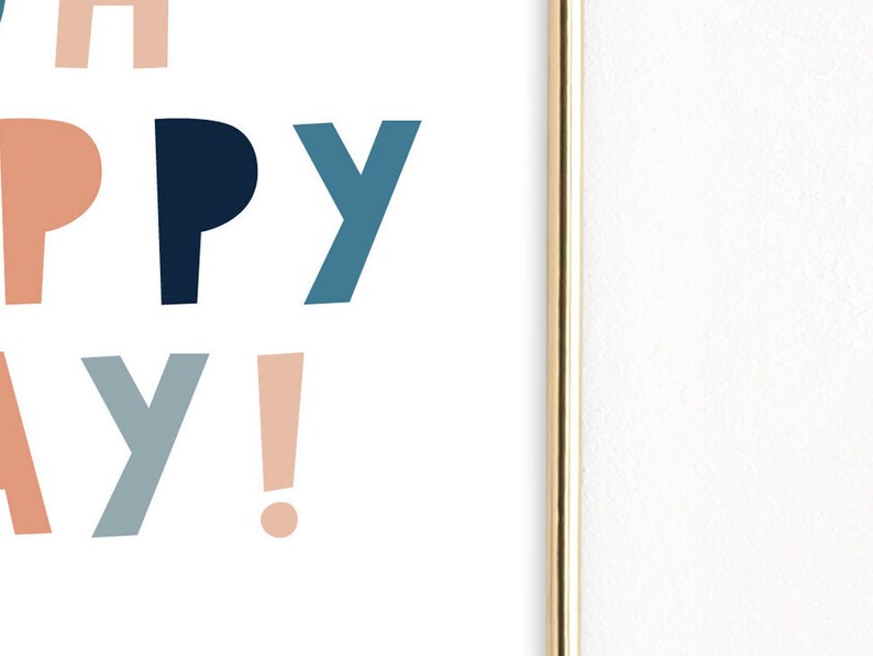 May include: A framed print with the words "HAPPY DAY!" in a playful, colorful font. The letters are in shades of peach, navy blue, and teal against a white background. The frame is gold.