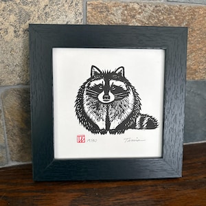 Mapache redondo en un marco cuadrado. Obra de arte original en linóleo firmada.