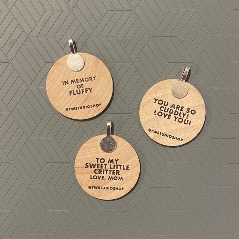 May include: Three round wooden ornaments with silver hangers. The ornaments have different messages engraved on them: "In memory of Fluffy", "You are so cuddly! Love you!" and "To my sweet little critter Love, Mom".