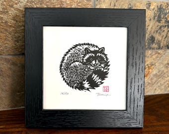 Round raccoon in a square frame. Original signed linocut art.