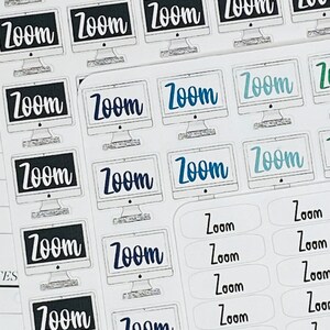 May include: A sheet of stickers featuring the word "Zoom" printed in various colours and fonts. Some stickers include a computer monitor icon. The stickers are designed for use in planners and journals.