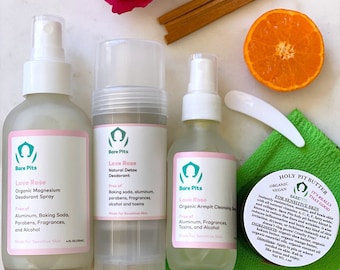 May include: An assortment of Bare Pits skincare products, including deodorant spray, natural detox deodorant, and armpit cleansing spray. The products are labeled "Love Rose" and are free of aluminum, baking soda, parabens, fragrances, and alcohol. Also shown are a jar of "Holy Pit Butter", a rose, and an orange slice.